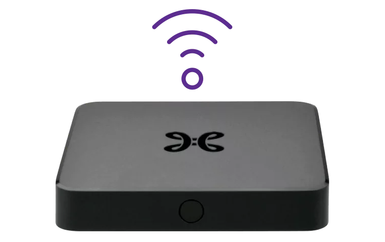 De TV Box Android Wi-Fi heeft een ronde knop in het midden van de voorkant. De bovenkant van het toestel is plat.