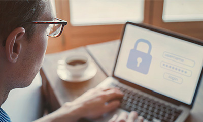 vrouw zit voor een laptop met haar koffie